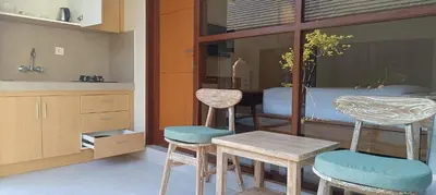 a kitchen with a table and two chairs and a bed at Kubunaku Sanur Bali in Sanur