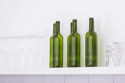 three green bottles are sitting on a shelf at Saro - Top location near Potato Head, walk everywhere! in Seminyak