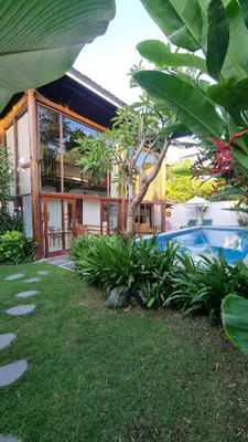 a house with a swimming pool in front of it at 2 Minutes Walk to the Beach 3BR Retreat Villa in Canggu