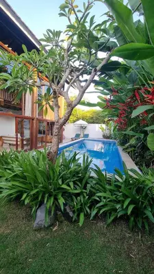 a tree and a swimming pool in front of a house at 2 Minutes Walk to the Beach 3BR Retreat Villa in Canggu