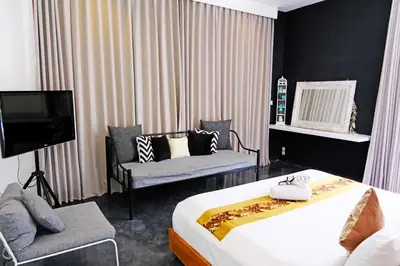 a bedroom with a bed and a tv and a couch at Modern & Central 3 Bedroom plus cinema in Seminyak
