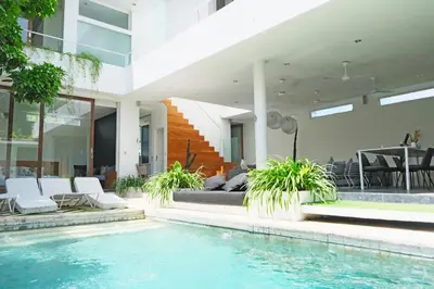 a villa with a swimming pool and a house at Modern & Central 3 Bedroom plus cinema in Seminyak