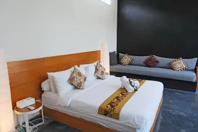 a bedroom with a bed and a couch at Modern & Central 3 Bedroom plus cinema in Seminyak