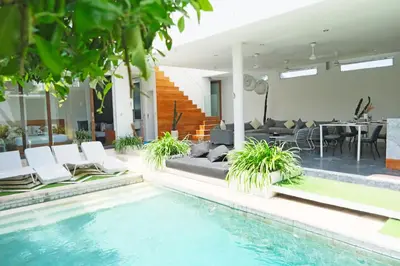 a house with a swimming pool and a living room at Modern & Central 3 Bedroom plus cinema in Seminyak