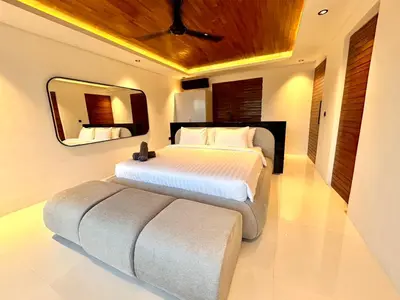 a bedroom with a large bed and a mirror at Villa Kawis Seminyak in Seminyak