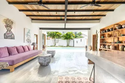a living room with a purple couch and a table at Villa N'Zo By DreamAwayBali in Seminyak