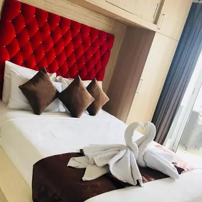 two swans sitting on a bed in a hotel room at 5 bedroom villa in kuta with 2 swimingpool in Kuta