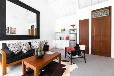 a living room with a black couch and a table at Ti - 1BR pool villa in the heart of Seminyak in Seminyak