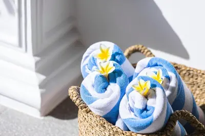 a basket filled with towels with flowers in them at Ti - 1BR pool villa in the heart of Seminyak in Seminyak