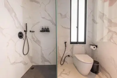 a bathroom with a toilet and a window at Villa Kamawis Seminyak in Seminyak