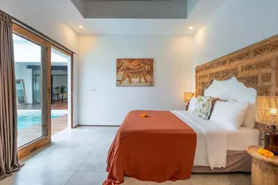 a bedroom with a large bed and a pool at Villa Wuizy By DreamAwayBali in Seminyak