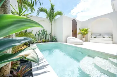 a swimming pool in a garden with plants at Villa Benteke Umalas in Kerobokan