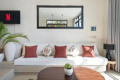 a living room with a white couch with red pillows at Villa Benteke Umalas in Kerobokan