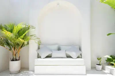 a white couch in a room with plants at Villa Benteke Umalas in Kerobokan