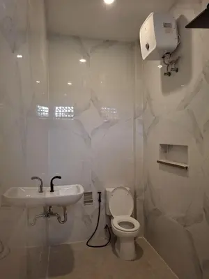 a white bathroom with a toilet and a sink at Ayoolasudi in Kerobokan