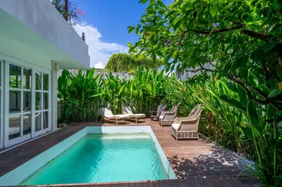 a patio with a pool and chairs and trees at 2BR Villa walking distance to Finns & Atlas in Canggu