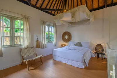 a bedroom with a bed and a chair and windows at 2BR Villa in Umalas next to Seminyak & Canggu in Kerobokan