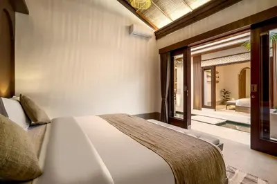 a bedroom with a bed and a sliding glass door at Villa Advaya by Maheswara in Seminyak