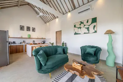 a living room with two green chairs and a table at La Palma - Spacious 2BR Villa with Large Pool in Canggu in Canggu