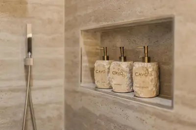 a shelf in a bathroom with four toiletries on it at CAVO Villa in Seminyak
