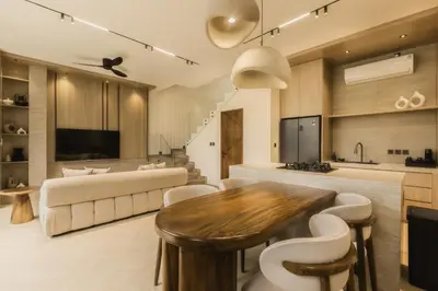 a living room with a table and a kitchen at CAVO Villa in Seminyak