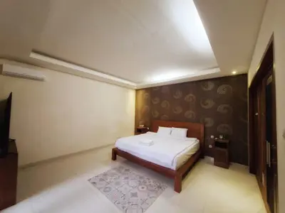 a bedroom with a bed and a television in it at Max Guest House in Seminyak