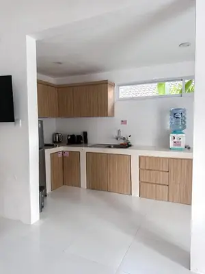 a kitchen with wooden cabinets and a window at The Pink Door Villa in Legian