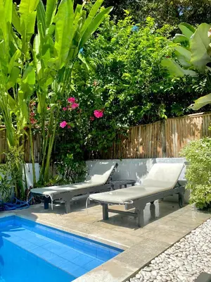 two lounge chairs and a pool in a garden at Villa Pastis Umalas #2, near Canggu in Canggu