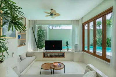 a living room with a couch and a tv at Villa Agua Dream Canggu hideaway in Canggu