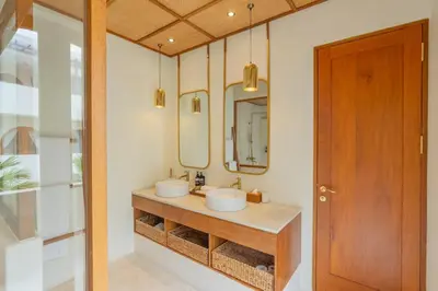 a bathroom with two sinks and two mirrors at Villa Agua Dream Canggu hideaway in Canggu