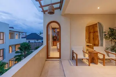 a balcony of a house with a table and chairs at Villa Agua Dream Canggu hideaway in Canggu