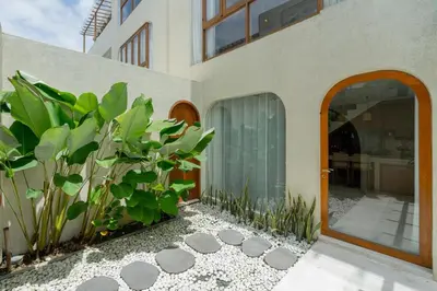 a house with a glass door and some plants at Villa Agua Dream Canggu hideaway in Canggu