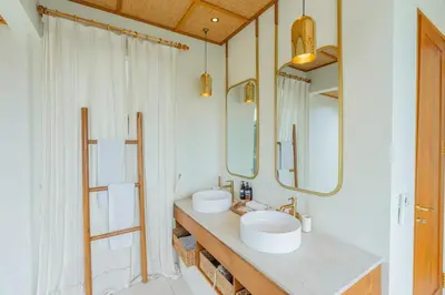 a bathroom with two sinks and two mirrors at Villa Agua Dream Canggu hideaway in Canggu