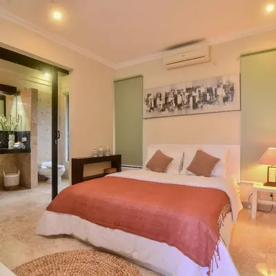a bedroom with a large bed with a red blanket at Villa EL Noya Umallas in Badung