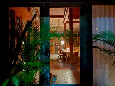 a dining room with a table and some plants at Spacious Family Home & Office Canggu, stay with cats in Canggu