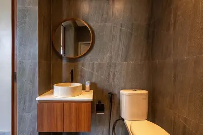 a bathroom with a toilet and a mirror at Solencia Villa by Betterplace in Jimbaran