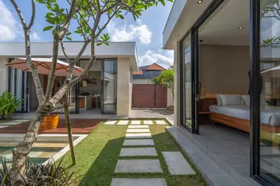 an internal courtyard of a house with a bed and a garden at Solencia Villa by Betterplace in Jimbaran