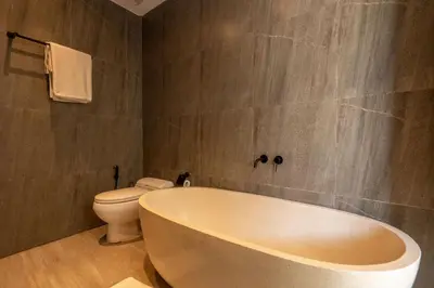 a bathroom with a tub and a toilet at Solencia Villa by Betterplace in Jimbaran