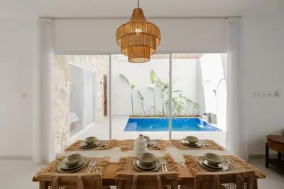 a dining room with a table and a large window at Casa De Vero Amore in Jimbaran