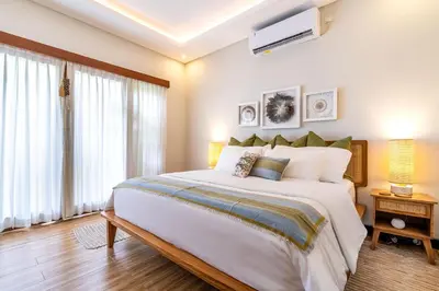 a bedroom with a large white bed and a window at Tropical 2BR Villa with Private Pool in Canggu in Canggu