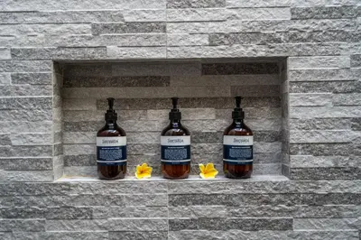 three bottles of whiskey on a brick wall at Tropical 2BR Villa with Private Pool in Canggu in Canggu