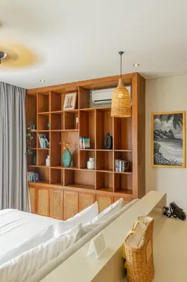 a bedroom with a bed and a book shelf at Villa Viento Tropical Haven Canggu in Canggu