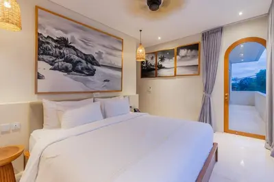a bedroom with a large white bed and a window at Villa Viento Tropical Haven Canggu in Canggu