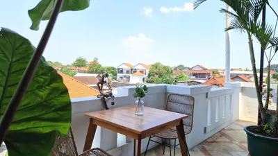 a table and chairs on a balcony with a view at Nice Place To Stay - Rooftop Apartments in Seminyak
