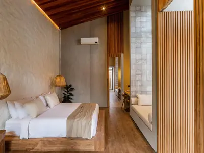 a bedroom with a bed and a couch at House of Winds Complex - Lush 9BR Exotic Escape - 3x3BR Villas near Canggu in Kerobokan