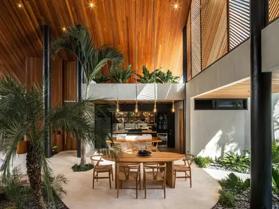 a dining room with a table and some plants at House of Winds Complex - Lush 9BR Exotic Escape - 3x3BR Villas near Canggu in Kerobokan