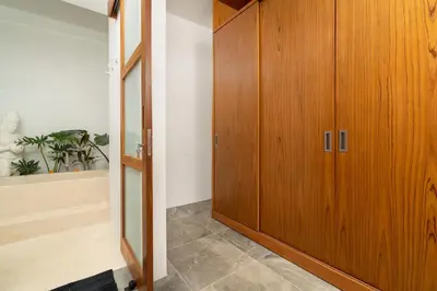 a hallway with a wooden cabinet and a plant at Villa Sunset Waters in Legian