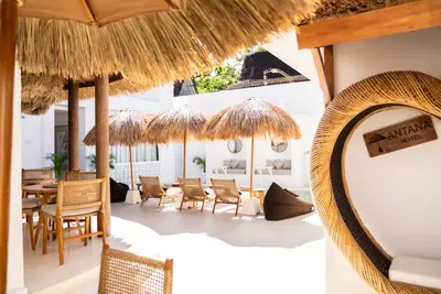a restaurant with tables and chairs and umbrellas at Antana Hotel in Canggu