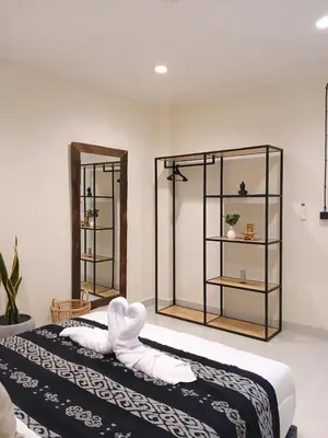 two beds in a room with two shelves at Nice Place To Stay - Cozy Living in Seminyak