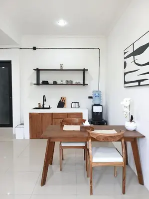 a dining room with a wooden table and chairs at Nice Place To Stay - Cozy Living in Seminyak